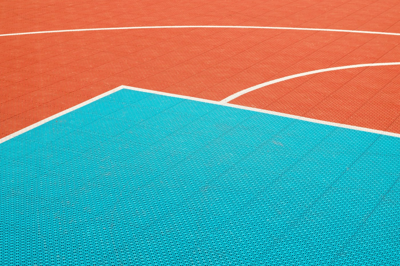 Orange and teal court paint with white lane and arc lines